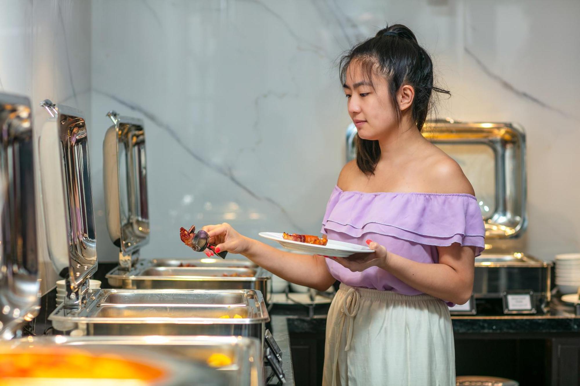 메이 드 빌 올드 쿼터 호텔 하노이 외부 사진 A woman serving herself at a buffet